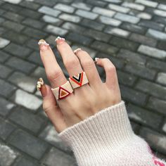 a woman's hand with three rings on it and one ring in the middle