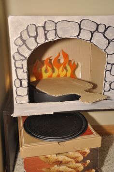 an open cardboard box sitting on top of a pizza oven with flames coming out of it