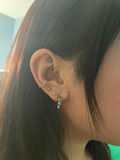 a close up of a person with ear piercings on their ears and behind the ear