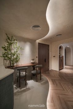 an elegant dining room with wood floors and white walls, along with a round wooden table surrounded by chairs