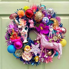 a close up of a wreath on a door with toys and ornaments around it,