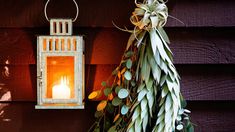 a lit candle is hanging on the wall next to a christmas tree and other decorations