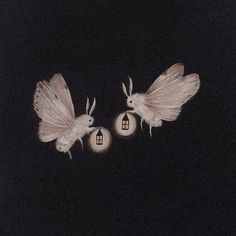 two white birds flying over a house in the air at night with lights on it's wings