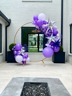 purple and silver balloons in front of a building with a star decoration on the door