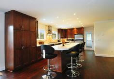 a kitchen with two bar stools next to an island