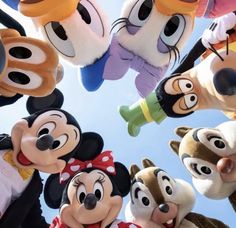 many mickey mouses are standing together in the air with their faces painted like cartoon characters