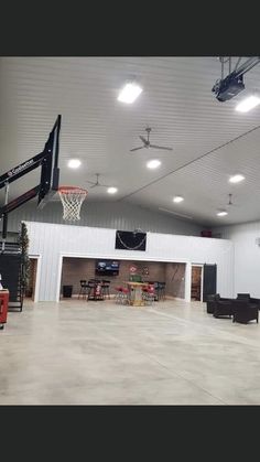 an indoor basketball court with chairs and tables in the center, lights on above it