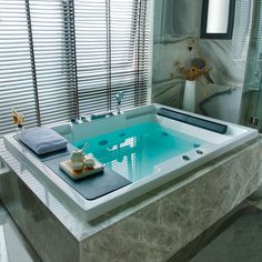 a bathroom with a large jacuzzi tub next to a window