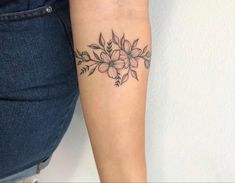 a woman's arm with a flower tattoo on the left side of her body