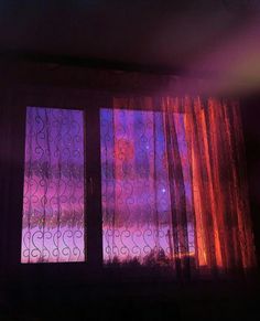 an open window with curtains in front of it and the sun shining through on the outside