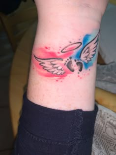 a person with a tattoo on their wrist that has an image of a bird flying in the sky