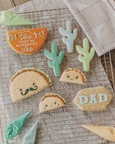 cookies decorated with the words dad and mustaches are on a cooling rack next to cactuses