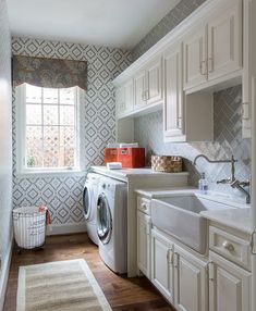 a washer and dryer in a small room next to a window with curtains