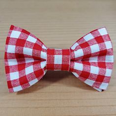 a red and white bow tie sitting on top of a wooden table