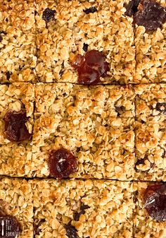 homemade granola bars with raisins and cherries cut into squares on top