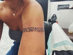 a woman with a tattoo on her arm sitting in front of a table and chair