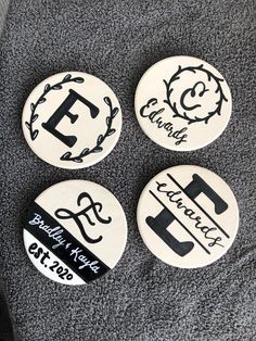 three badges with the letters e, f, and c on them sitting on a gray blanket