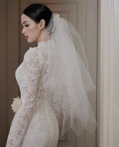 a woman in a wedding dress with a veil on her head