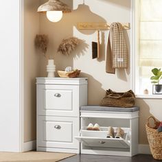 a white shoe rack with shoes on it next to a dresser and chair in a room