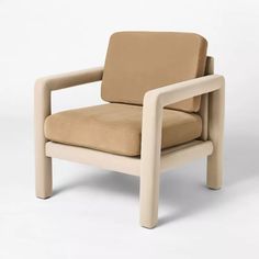 a beige chair sitting on top of a white floor next to a wooden armrest