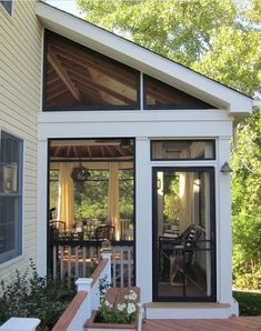 a small white house with an enclosed porch