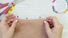 the woman is making pins on her body with scissors and needle tip needles in front of them