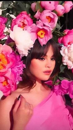 a woman in a pink dress surrounded by flowers