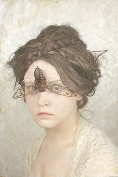 a woman with glasses and a butterfly on her forehead is shown in this artistic photo