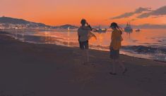 two people walking on the beach at sunset