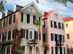 a row of multi - colored houses with palm trees in the foreground