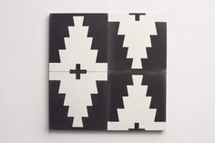 two black and white tiles with crosses on the top one is made out of paper