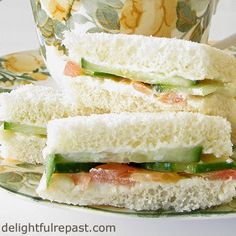 two sandwiches stacked on top of each other next to a coffee cup and saucer