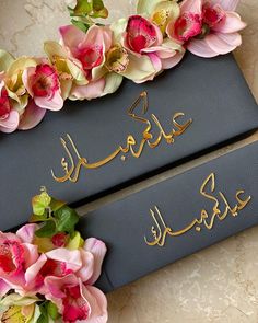 two black boxes with gold lettering and flowers