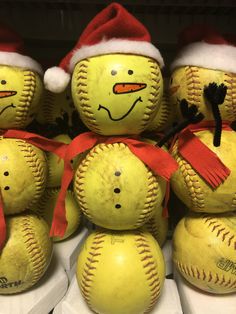 a group of yellow baseballs with hats and scarves on them, sitting next to each other