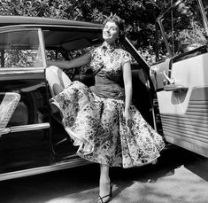 a woman sitting in the back of a car with her legs up and holding onto the door