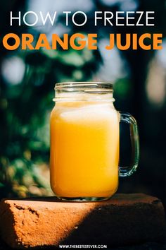 a mason jar filled with orange juice sitting on top of a piece of wood