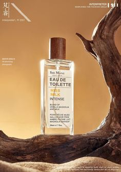 a bottle of cologne sitting on top of a wooden branch next to a piece of driftwood