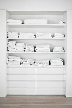 a white closet filled with lots of clothes