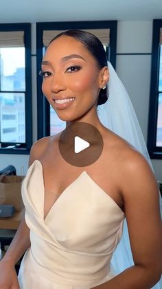 a woman in a wedding dress standing next to a window and smiling at the camera