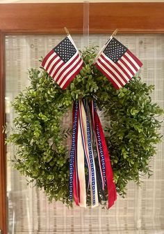 a wreath with two american flags hanging from it