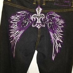 a pair of black jeans with purple and white wings on them