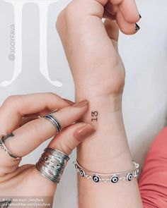 two women with matching rings on their wrist and one holding the other's hand