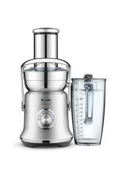 a silver and gold juicer next to a blender on a white background with a measuring cup