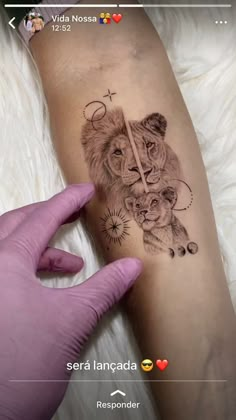 someone is holding their arm with a tattoo on it that has a lion and cross on it