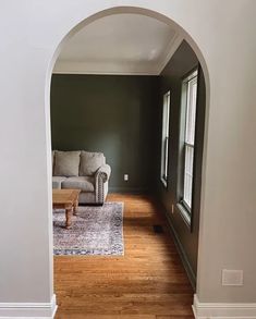 an archway leading into a living room with a couch and coffee table in the corner