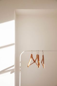 three pairs of wooden clothes hangers in a white room