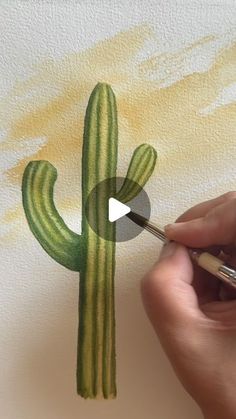 someone is painting a cactus with watercolors