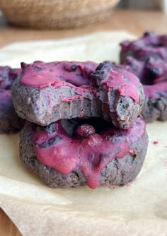 three cookies with blueberries are stacked on top of each other and have pink frosting