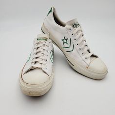 This product is a vintage pair of Converse Pro All Star Archive Leather Sneakers in white with green accents. They are a limited edition release from the 1970s, featuring a low top silhouette with a lace-up closure. The shoes are made of leather with a fabric lining and insole, and have a standard width. They are unisex and come in US and UK size 9.5, and EU size 43. The sneakers are suitable for walking and skateboarding, and are perfect for activewear or casual occasi White And Green Sneakers, 70s Converse, Mens Tie, Green Sneakers, Green Accents, Tie Shoes, Converse All Star, Shoes Trainers, Converse Shoes