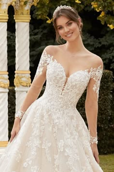 a woman in a wedding dress posing for the camera with her hands on her hips